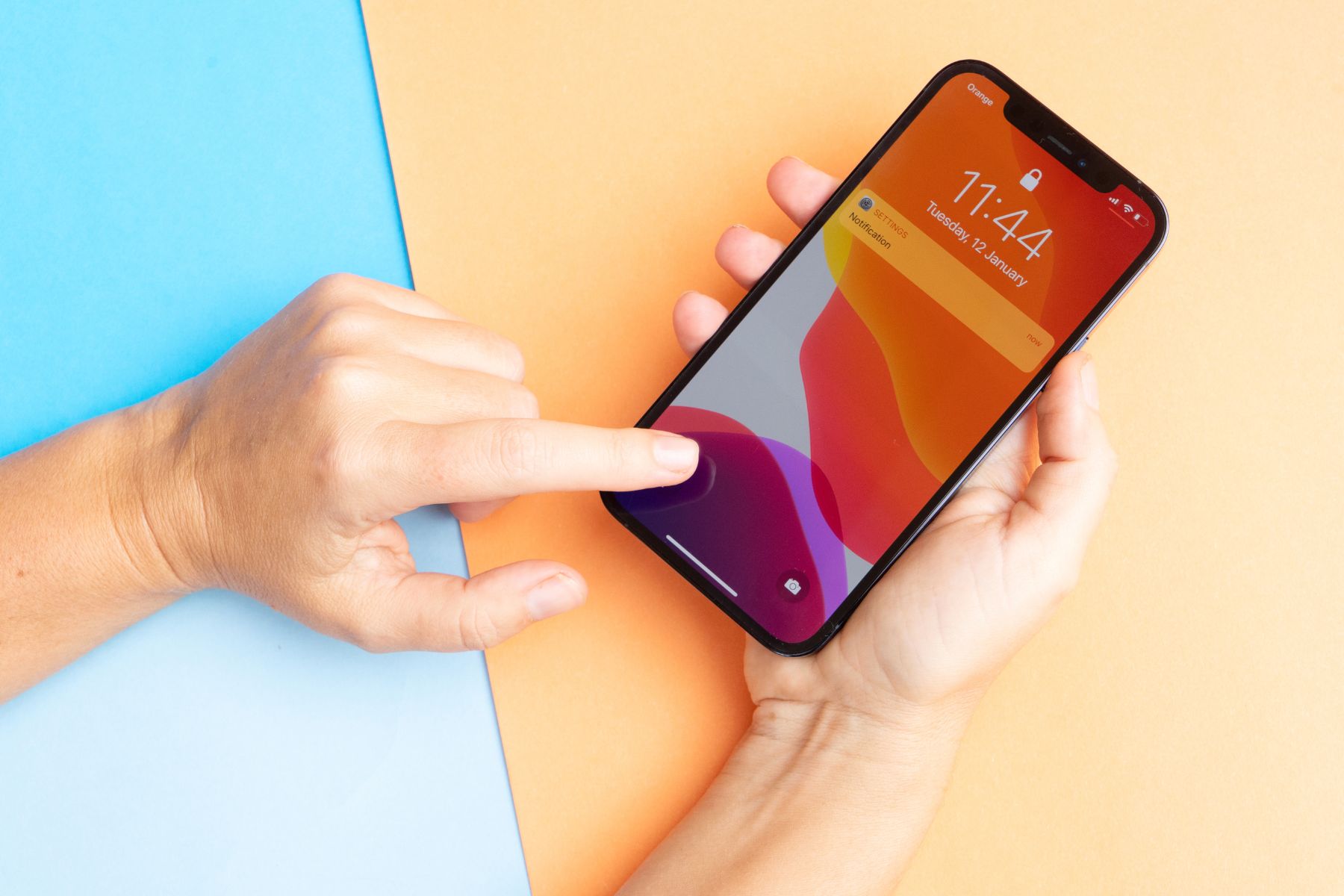 Close-up of a hand holding an iPhone while navigating a mobile banking app.