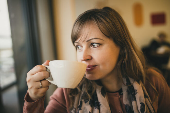 Woman sipping from a coffee cup.