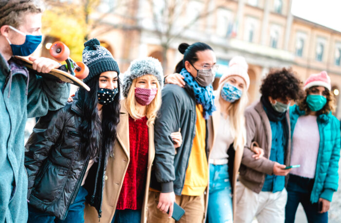 Group of friends bundled up to stay warm enjoying each other's company outdoors